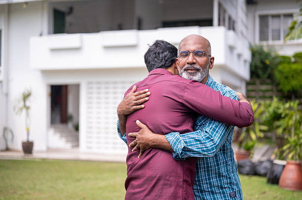 istock An Asian son welcomes his father home with a warm hug. 2239543968
