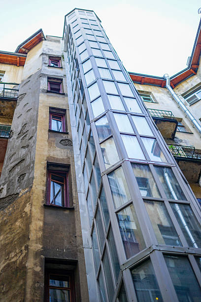 istock Exterior glass elevator attached to an old building 2239545538