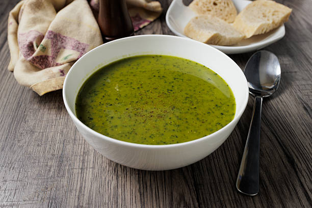 A close-up of a vibrant green lentil and kale soup, perfect for a vegan diet.