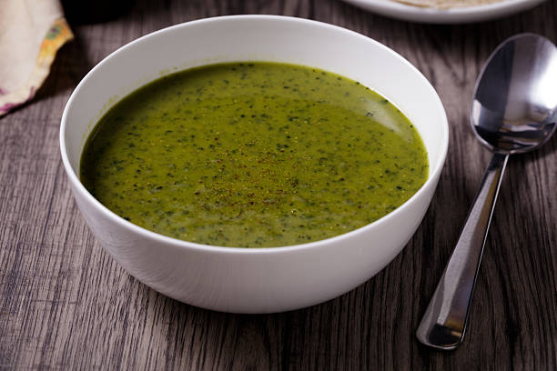 A close-up of a vibrant green lentil and kale soup, perfect for a vegan diet.