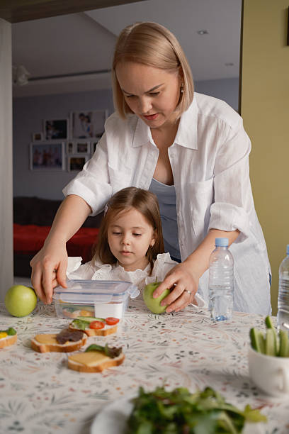 istock Mother and daughter preparing a healthy lunch for school 2239547310