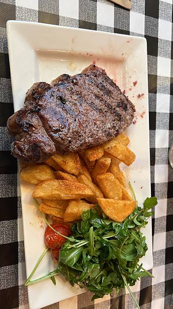 A nice steak with some wedges and salad