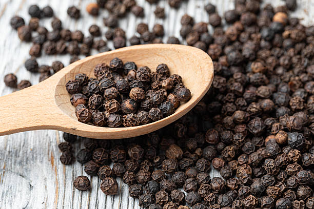istock black pepper on wooden spoon 2239551189
