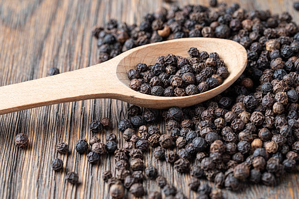istock black pepper on wooden spoon 2239551198