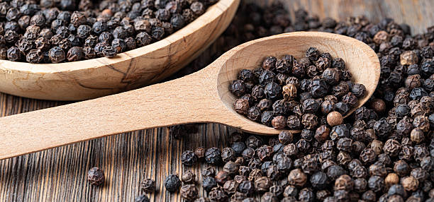 istock black pepper on wooden spoon 2239551216