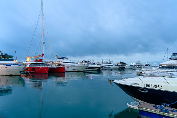 Sochi, Russia - January 23, 2025: Luxury yachts at sunset on a cloudy winter day. Sochi seaport. Long exposure.