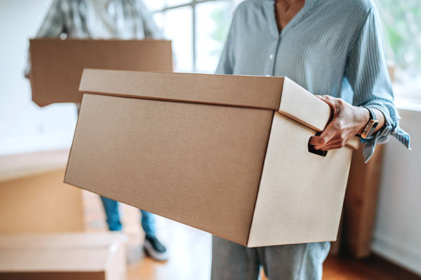 istock Close-up of couple’s hands holding moving box 2239553223