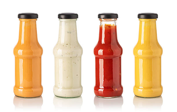istock Four glass bottles containing different sauces on white background 2239555093