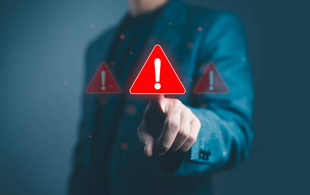 istock Businessman touching red warning alert icon on virtual screen, symbolizing cybersecurity risk, system error, data protection alert, and online security breach prevention concept in digital technology. 2239555275