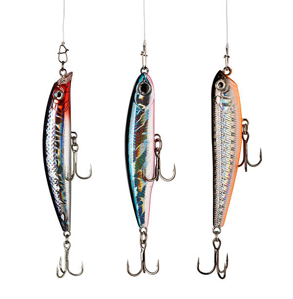 istock Three fishing lures hanging on white background showing hooks 2239555387
