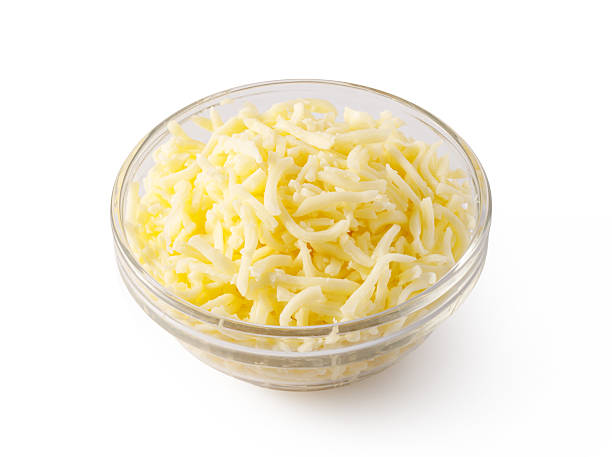 istock Grated cheese overflowing a small glass bowl on white background 2239556791