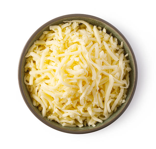 istock Grated cheese overflowing a bowl on white background 2239556797