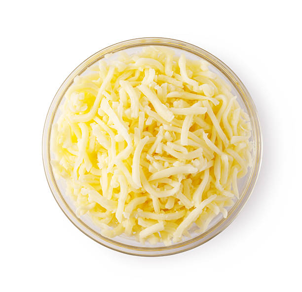 istock Grated cheese overflowing a glass bowl on white background 2239556799
