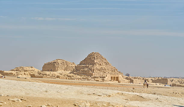 View of Egyptian pyramids in a desert setting, showcasing their historical significance and the surrounding sand dunes under a vibrant blue sky. A timeless representation of Ancient Egypt's architectural achievements.