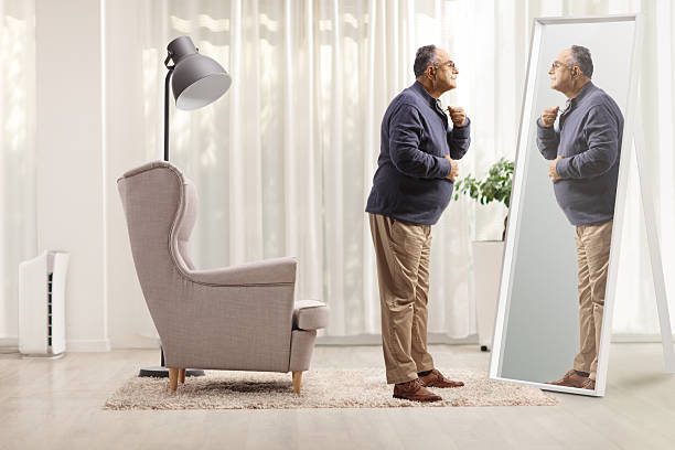 istock Mature man getting ready in front of a mirror 2239560094