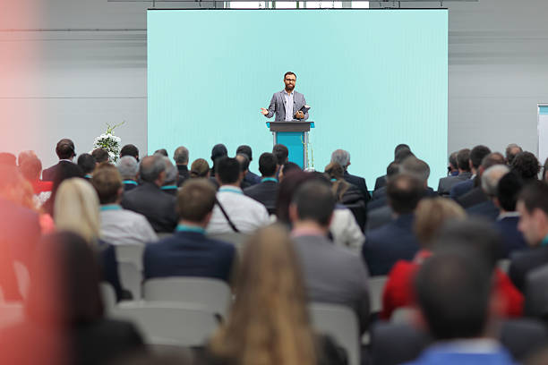 istock Man on stage in a hall in front of an audience 2239560450