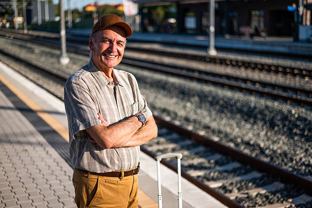 istock Senior man at railway station 2239560590