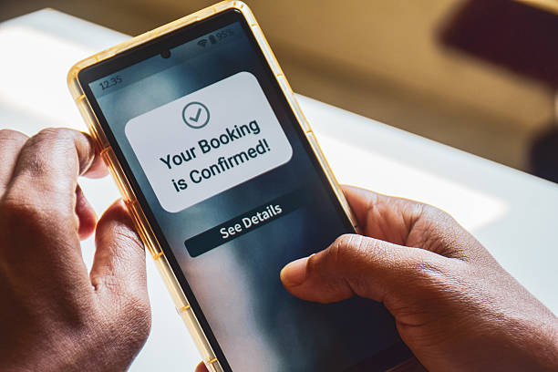 istock South Asian man holding phone displaying booking confirmation message. Hotel flight or train ticket online booking concept. Selective focus. 2239560819