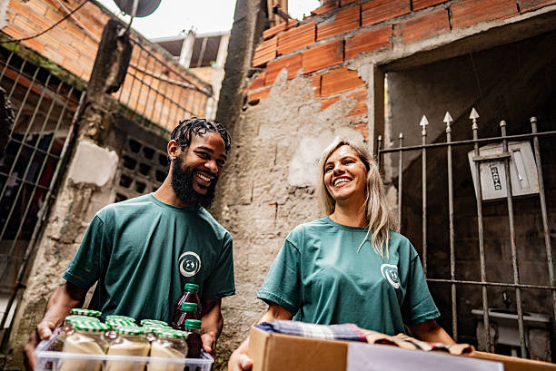 istock Volunteers talking and holding donation boxes outdoors 2239561413