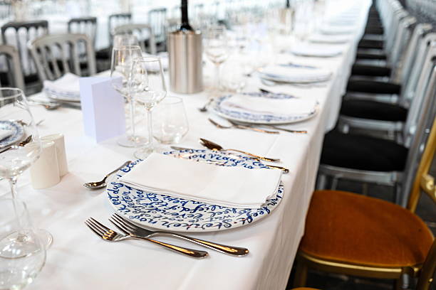 istock Empty, delft blue decorated ceramic dinner plate and silver cutlery arranged on a white table cloth. Top side view, shallow depth of field, no people 2239563526