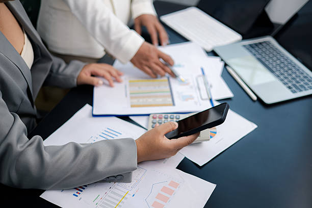 istock Businesswomen analyzing financial data using smartphone and laptop in modern office 2239564109