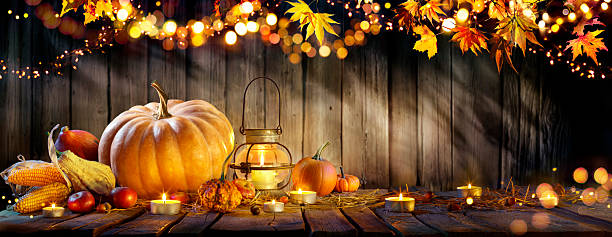 istock Thanksgiving - Pumpkins And Corncobs On Wooden Table With Rustic Garland And Defocused Abstract Lights 2239569776