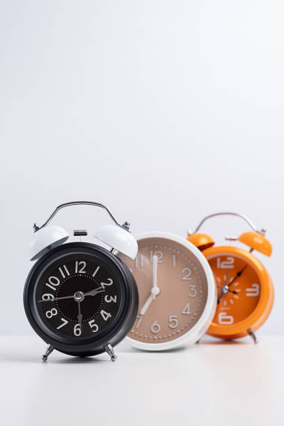 Different alarm clocks on a colored background. Time, business and technology concept. Time to get up early.