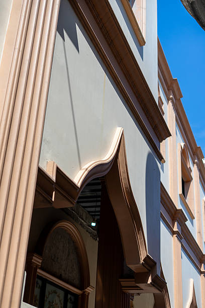 istock Elegant building facade with classical peach-colored architectural details under blue sky 2239585631
