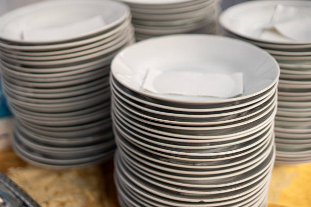 istock Tall stacks of clean white dinner plates prepared for guests 2239585657