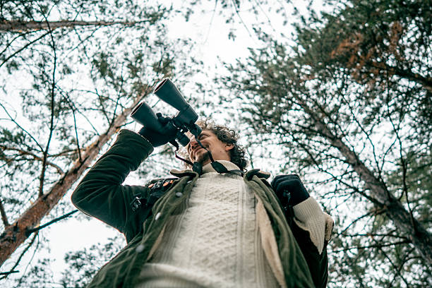 istock Birdwatcher in Forest Looking Through Binoculars, Exploring Nature and Wildlife 2239591345