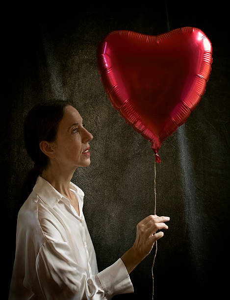 istock woman hugging a red balloon in a romantic attitude II 2239591369