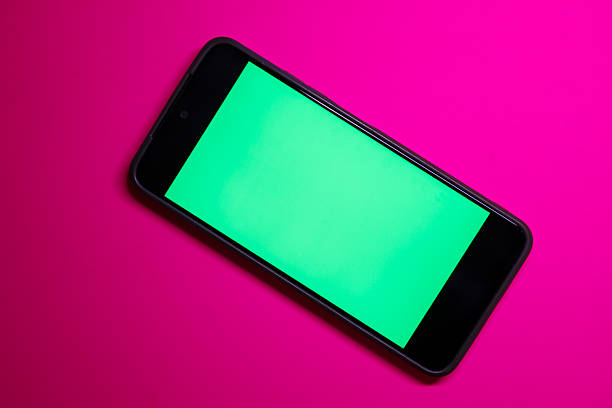 istock This shot is a perfect mockup for showcasing a mobile app, website, or advertising content. A smartphone with a bright green screen is positioned diagonally on a saturated pink background, creating 2239592235