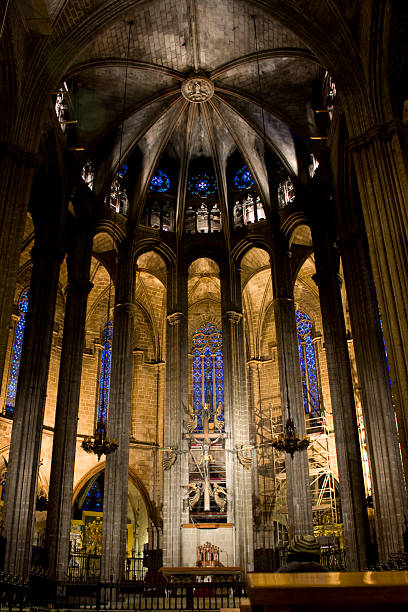 Barcelona Cathedral interior showcases soaring Gothic columns, ribbed vaults and luminous stained glass, bathing the medieval stone nave in warm, solemn light and historic grandeur