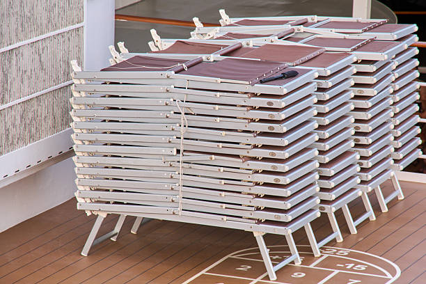 istock Folded lounge chairs stacked on a cruise ship deck, symbolizing storage or the end of the season. 2239594555