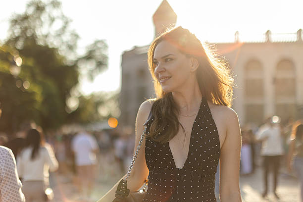 Beautiful young brunette is walking in Monmartre. She is wearing a beautiful summer dress, she is smiling, looking joyful.