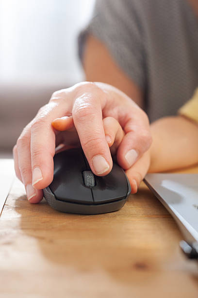 istock Close-up of child’s hand on mother’s while using computer mouse 2239595978