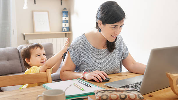 istock Child tapping mother’s back while she works focused on laptop 2239596132