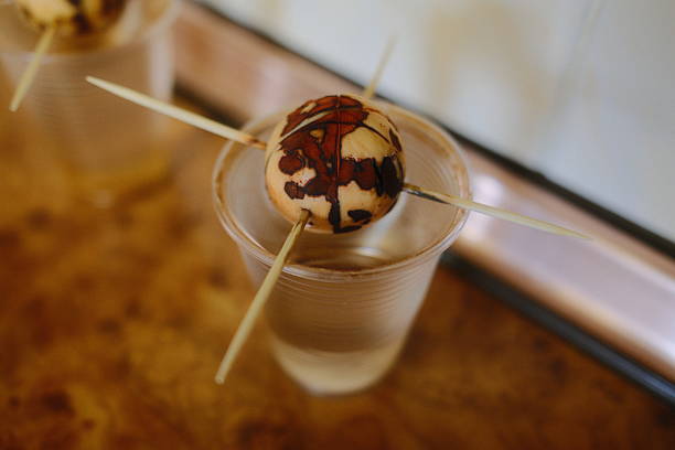 An avocado seed held by toothpicks sits in a clear plastic cup filled with water.