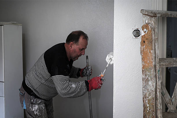 istock The painter is painting the house, using a paintbrush, house paint, and cleaning materials 2239599310