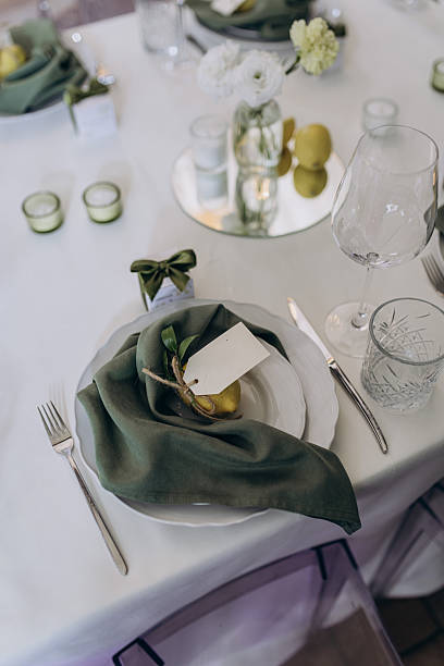 istock Elegantly Set Dining Table Featuring Green Napkins, Decorative Garnishes, Stylish Glassware, and Fresh Floral Arrangements for a Chic Dining Experience 2239601831