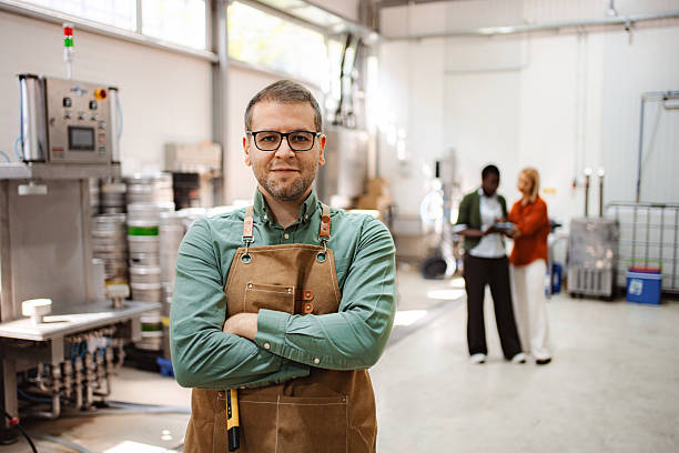 istock Brewer pouring craft beer for customers during brewery tour 2239612644