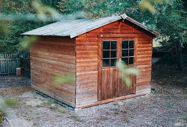 istock Wooden tool shed in garden with plants 2239614612