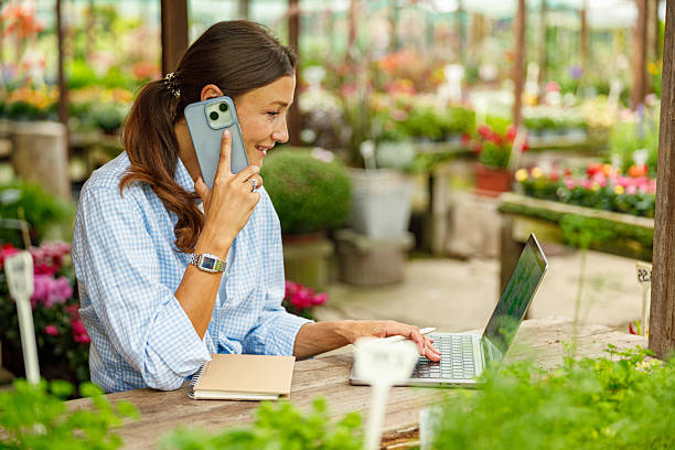 istock A Woman Engaged in Working Remotely Amidst a Lively and Beautiful Greenhouse Environment 2239617089
