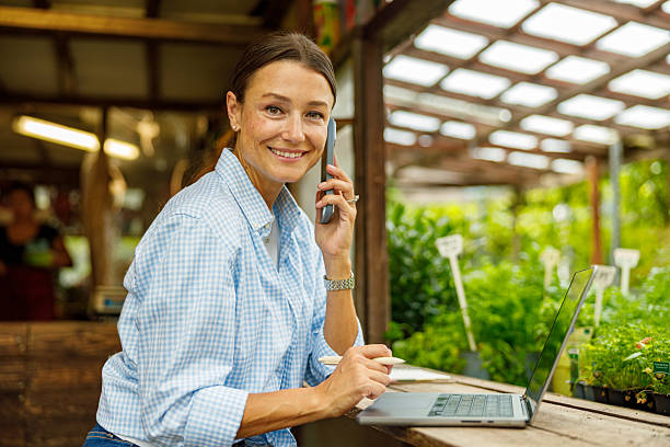 istock A Woman Skillfully Managing Various Work Tasks in a Greenhouse Environment Setting 2239618833