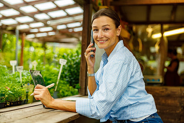 istock A Young Woman in a Bright Greenhouse Using a Smartphone While Taking Important Notes 2239624213