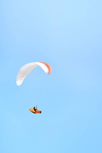 Paraglider Flying High in a Blue Sky Close up