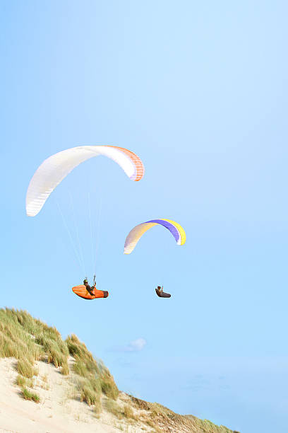 istock Colorful Paragliders Flying Above Beach and Dunes 2239624786