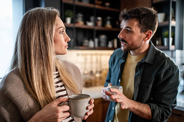 istock Couple having serious conversation in kitchen with coffee mugs 2239631304