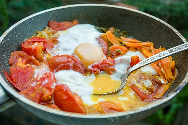 Scrambled eggs with stewed tomatoes and carrots in a frying pan is a tasty and healthy dish for breakfast, lunch or dinner.