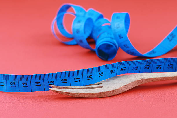 istock Wooden fork tied with twisted blue measuring tape 2239637271